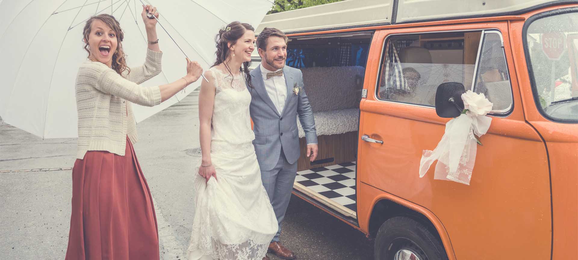 mariés souriants montent dans vieux bus VW avec chauffeur et sol à carreaux noirs et blancs